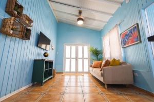 uma sala de estar com paredes azuis e um sofá em Jobos Beach Apt #2 near food truck and beach em Isabela