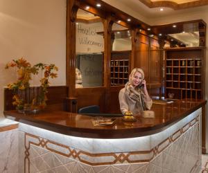 a woman sitting at a bar in a wine cellar at Hotel am Kochbrunnen in Wiesbaden