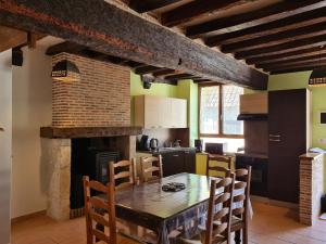 a kitchen with a table and chairs and a fireplace at Gîte 4 pers. avec terrasse privative entre Sologne et Châteaux de la Loire - FR-1-590-36 in Cléry-Saint-André