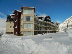 ein schneebedecktes Gebäude mit viel Schnee in der Unterkunft Catedral Ski & Summer in San Carlos de Bariloche