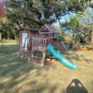 a playground with a slide and a play house at Blue Door Farmhouse in Meeker