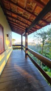 Casa Temporada - Petrópolis/RJ في بتروبوليس: شرفة منزل مطلة على الغابة