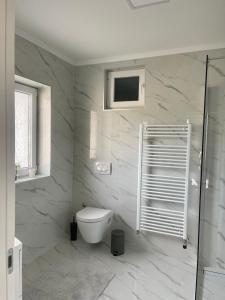 Un baño blanco con inodoro y ducha. en Rozi apartments, en Zagreb