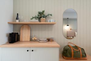 a kitchen with a shelf and a mirror at Hermitage Lodge in Pokolbin