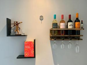 FLAT exclusivo no Hotel RAMADA Macaé, Smartv, Wifi 512Mbps, piscina e Garagem في ماكاي: مجموعة من زجاجات النبيذ على ثلاجة