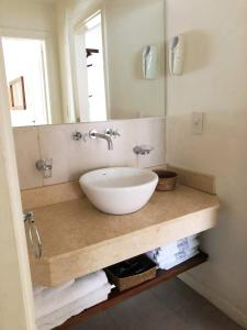 La salle de bains est pourvue d'un lavabo blanc et d'un miroir. dans l'établissement Catedral Ski & Summer, à San Carlos de Bariloche
