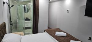 a room with a shower and a bed and a glass door at Apartmani COLOSSEUM in Bratunac +37 photos