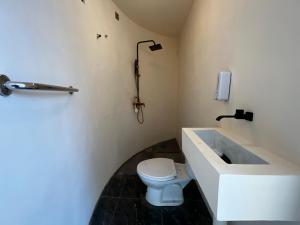 uma casa de banho com um lavatório e um WC em Highland Bali em Baturaja
