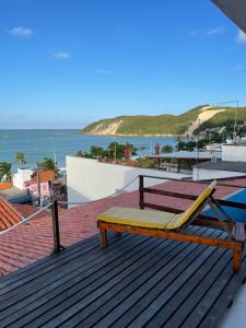 un banc sur un toit avec vue sur l'océan dans l'établissement Encanto da Praia hotel pousada, à Natal