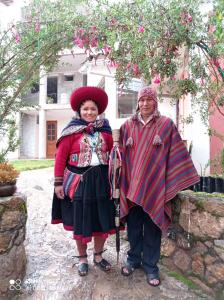 Un uomo e una donna in piedi davanti a una casa di Casa Tejedora a Chincheros