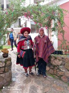 due persone in piedi davanti a una casa di Casa Tejedora a Chincheros