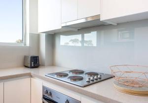 a kitchen with a stove top oven in a kitchen at Mosman Bay Magic - Harbourview Studio with Rooftop in Sydney