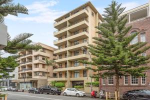 um prédio de apartamentos com uma árvore de Natal em frente em Fine Pine - Beachside Lifestyle with Two Balconies em Sydney