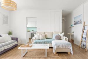 uma sala de estar com um sofá e uma mesa de centro em Fine Pine - Beachside Lifestyle with Two Balconies em Sydney