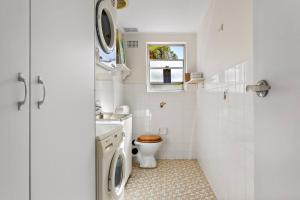 a white bathroom with a toilet and a sink at The Little Manly - Laidback Waterfront Magic in Sydney