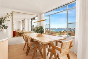 a dining room with a table and a large window at Harbour Bliss - Exquisite Design, Breathtaking Views in Sydney