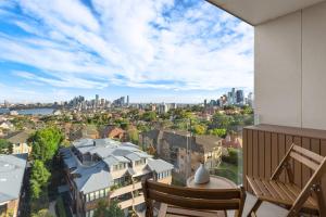 a balcony with two chairs and a view of a city at Harbour Bliss - Exquisite Design, Breathtaking Views in Sydney