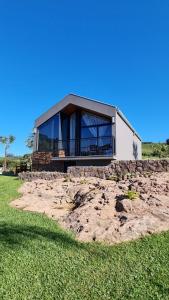 a house with a large window on top of a field at CABANAS LE VIGNE in Pinto Bandeira