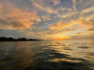a view of a sunset from a boat in the water at Apartamentos Manik in Trujillo