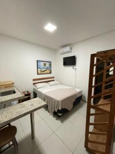 a bedroom with a bed and a television in it at Encanto da Praia hotel pousada in Natal