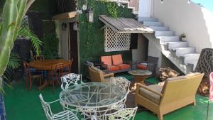 a patio with a table and chairs and a table and stairs at Tree Cabin in Tijuana