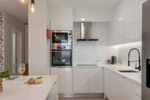 a white kitchen with white cabinets and appliances at In the touristic area and with a balcony Casa Branca VI in Funchal