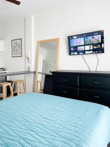 a bedroom with a bed with a television on the wall at Departamentos Huerta in Ciudad Fernández