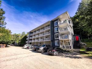 a building with cars parked in front of it at Condo moderne, escapade vacance, vue sur montagnes in Mont-Tremblant