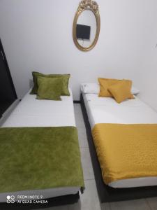 dos camas sentadas una al lado de la otra en una habitación en apartamento cerca a parque del Café en guaduales, en Montenegro