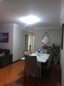 布盧梅瑙的住宿－Quarto para Casal Blumenau，客厅配有桌椅和灯