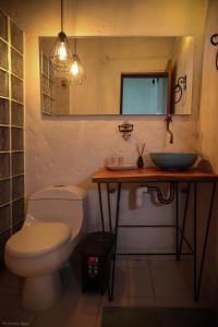 bagno con servizi igienici, lavandino e specchio di La Cabaña Cleves a Neiva