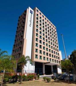 a tall building with a sign on the side of it at Flat 213 - Comfort Hotel Taguatinga in Taguatinga