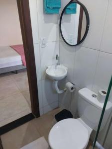a bathroom with a toilet and a sink and a mirror at Sobrado Flor de Maio in Milho Verde