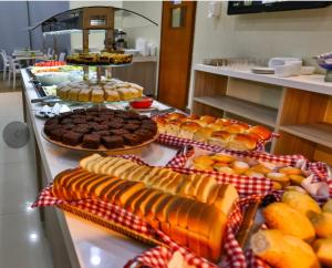 a buffet with many different types of cakes and pastries at Flat 213 - Comfort Hotel Taguatinga in Taguatinga