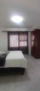 a bedroom with a bed and two windows in it at Esteem Guesthouse in Okakarara