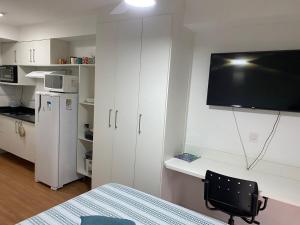 um quarto com uma cozinha com uma televisão e uma cadeira em Flat São Paulo - Expo Center , Anhembi, Rodov Tietê em São Paulo