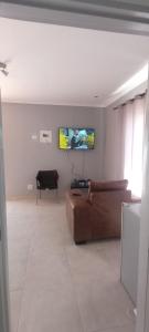 sala de estar con sofá y TV en la pared en Esteem Guesthouse, en Okakarara