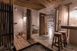 baño con aseo y taburetes en Suítes Casa Kamayurá, en Trancoso