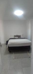 1 dormitorio con 1 cama en una habitación blanca en Esteem Guesthouse, en Okakarara
