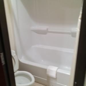 a bathroom with a white toilet and a bath tub at HiWay Inn Express in Coalgate