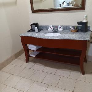 a bathroom with a sink and a mirror at HiWay Inn Express in Coalgate
