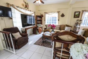 a living room with a couch and chairs and a table at Airport Inn in Piarco