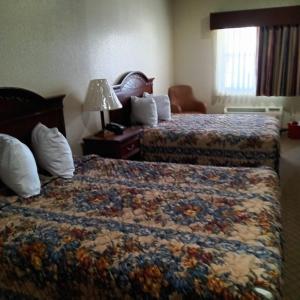 Una habitación de hotel con dos camas y una lámpara. en HiWay Inn Express, en Coalgate 1 foto más