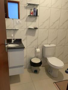 a white bathroom with a toilet and a sink at Cleyton Morada in Curitiba