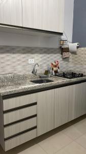 a kitchen with a sink and a counter top at Cleyton Morada in Curitiba