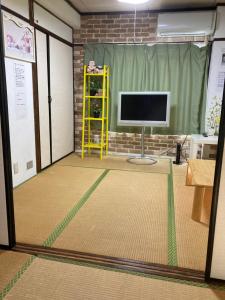 uma vista para um quarto com uma televisão e uma mesa em 山下ビル５０１ em Sutara