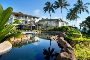 un complexe avec une piscine et des palmiers dans l'établissement The Westin Princeville Ocean Resort Villas, à Princeville