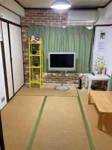 a living room with a television in a brick wall at 山下ビル５０１ in Sutara
