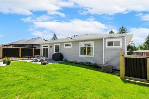 a house with a yard with a fence at Modern 2BR Guest House in North Nanaimo in Nanaimo