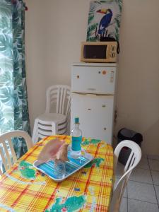 a table with a plate with a bottle on it at Holidays in Martinique - Ravenala in Sainte-Anne